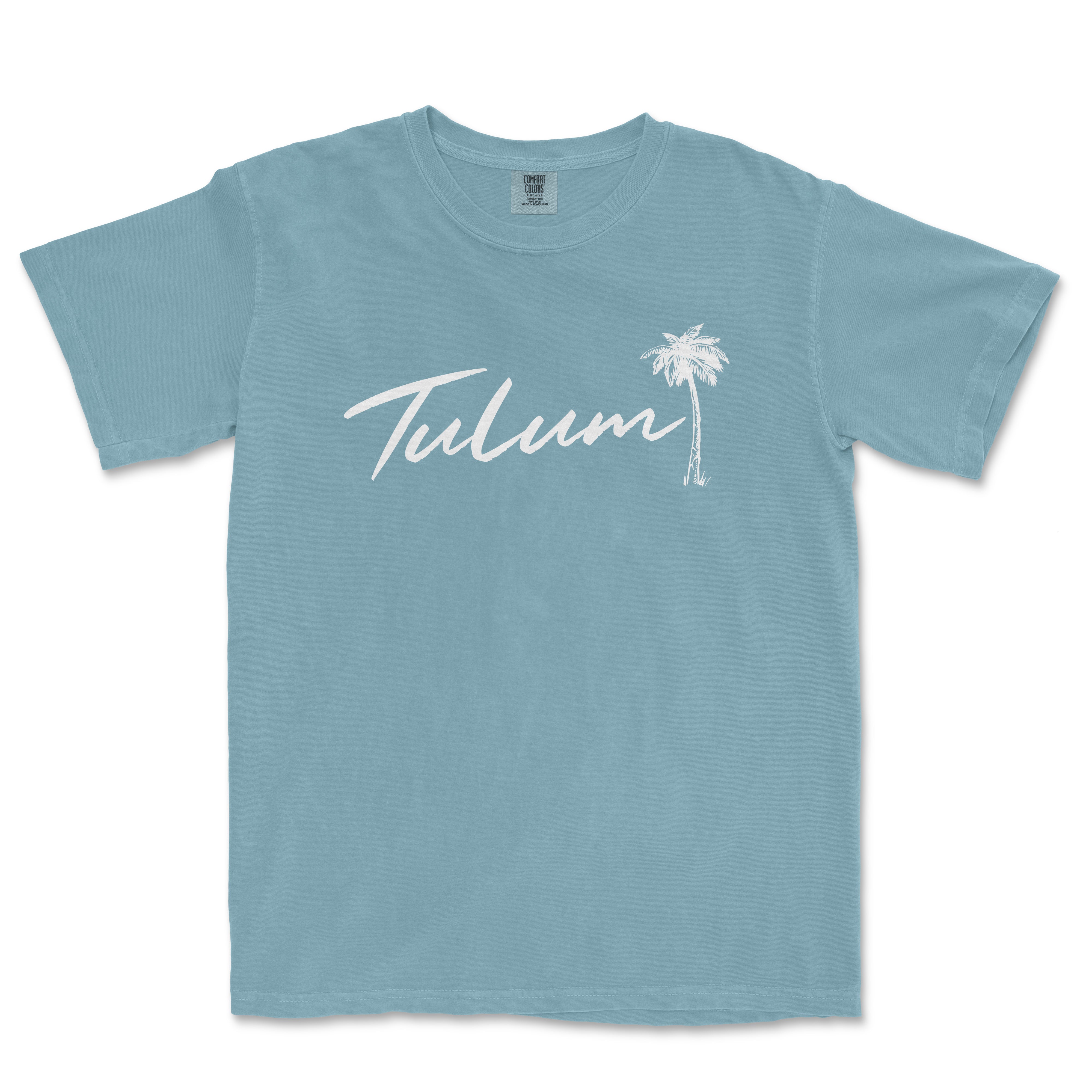 a light blue t - shirt with the word tulum written in white