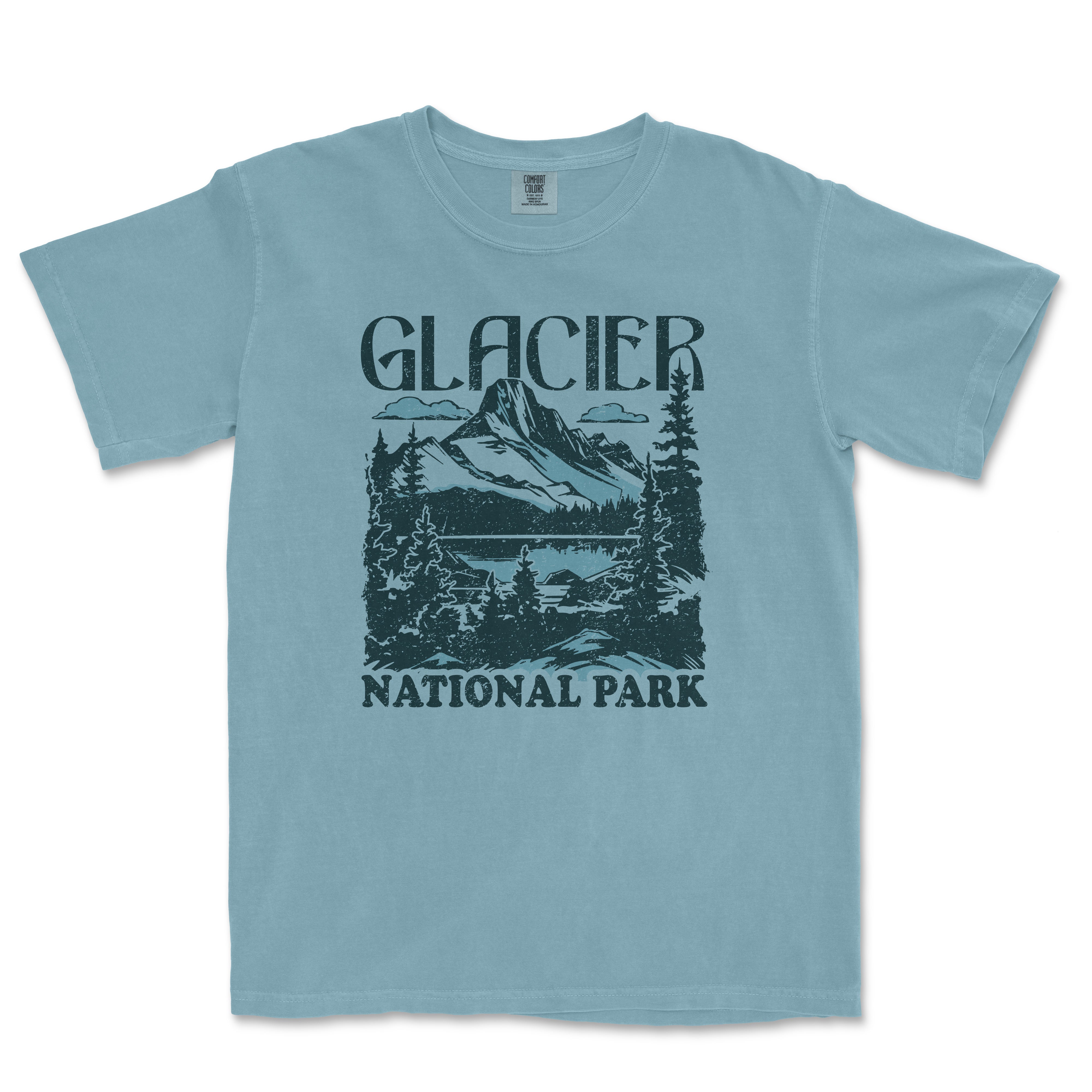 a light blue t - shirt with a picture of a mountain and trees