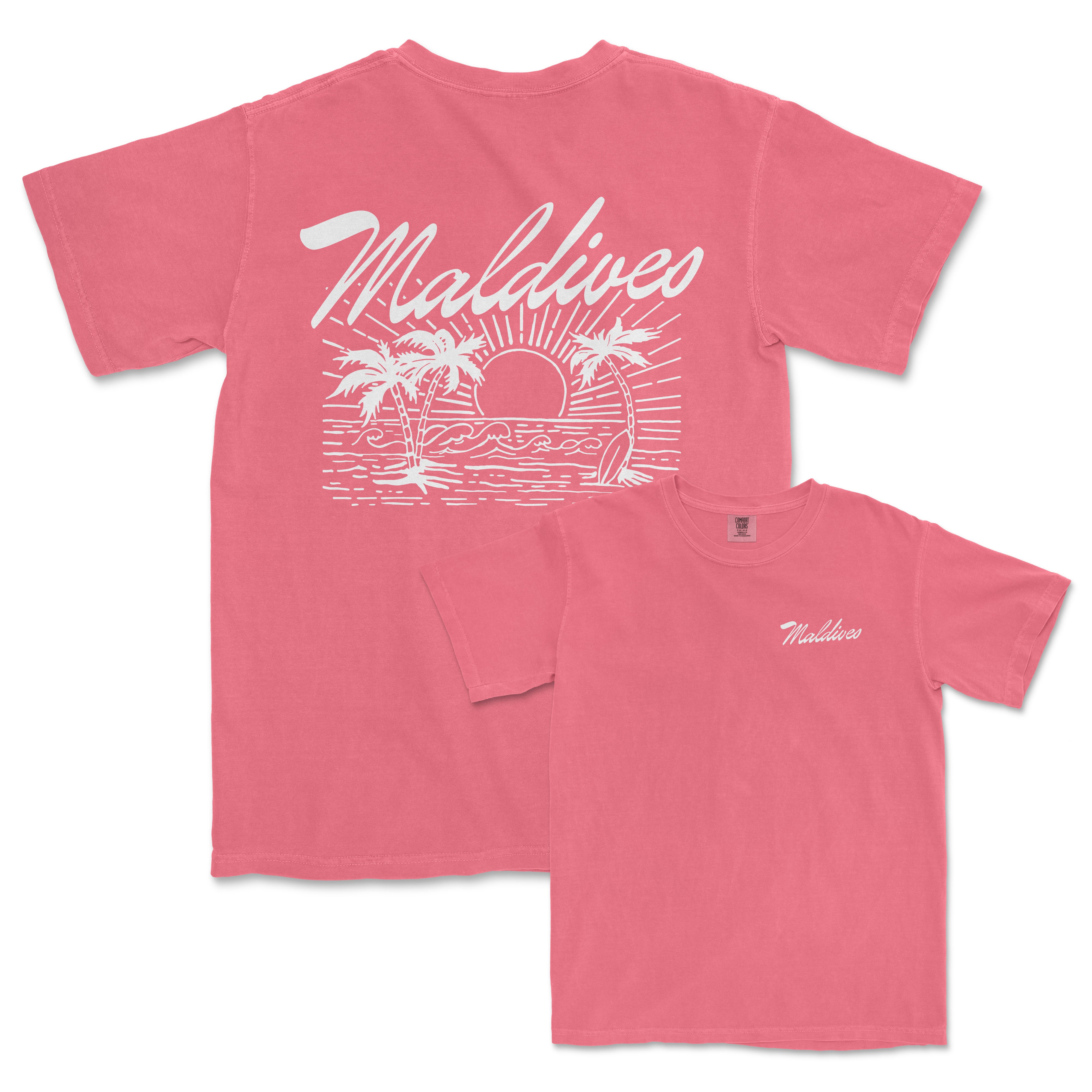 a pink t - shirt with a palm tree and sun on it